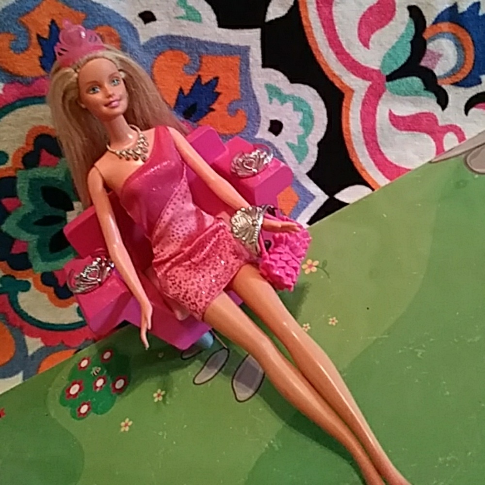 A Barbie 4 Tiaras, a purse ,2 dress, and a necklac